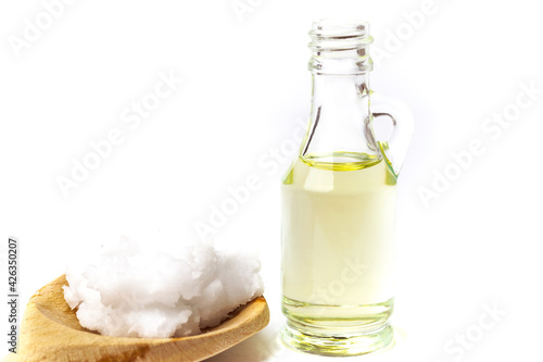 Unrefined coconut oil on a white background with wooden spoon
