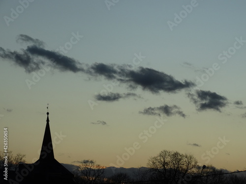 wieża kościelna na tle zachodu słońca  © Emil