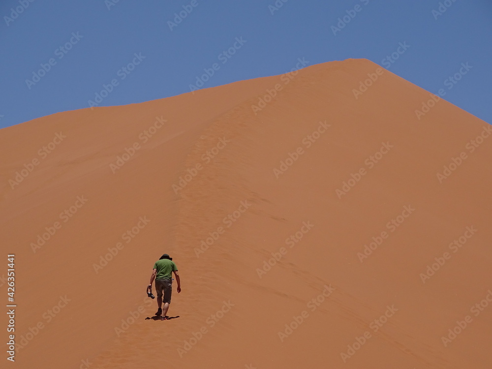 one man climbing up the dune 45 in sossusvlei one man climbing up the dune 45 in sossusvlei