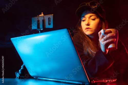 A girl blogger is sitting i...