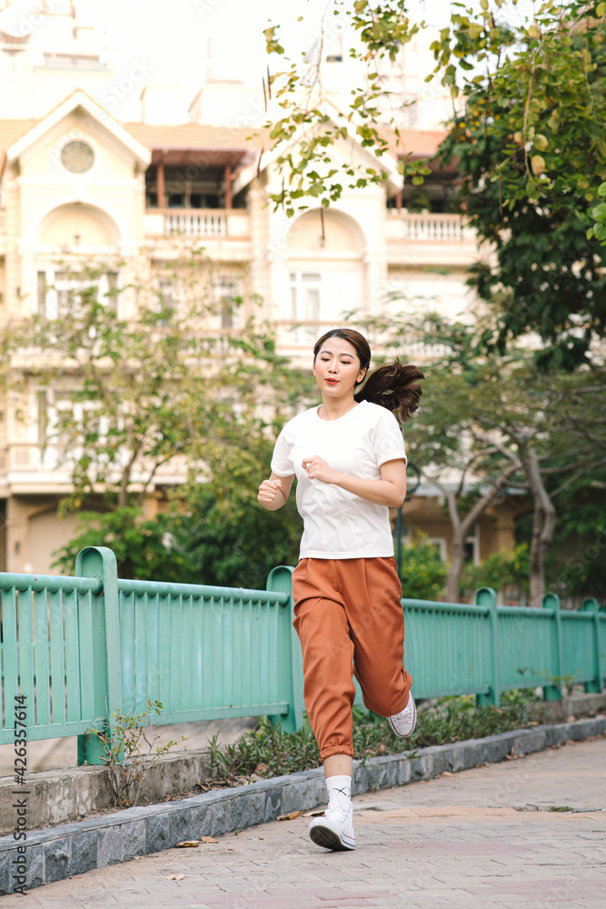 Healthy woman are running in the park in the morning. She smiled and enjoyed.