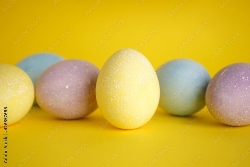 Colorful background of easter eggs on yellow background, close-up