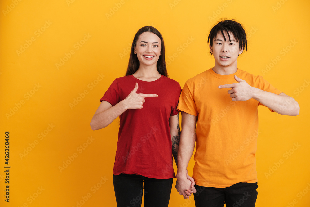 Young multiracial couple smiling and pointing fingers at each other