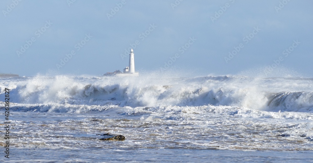 Wide waves and lighthouse in storm