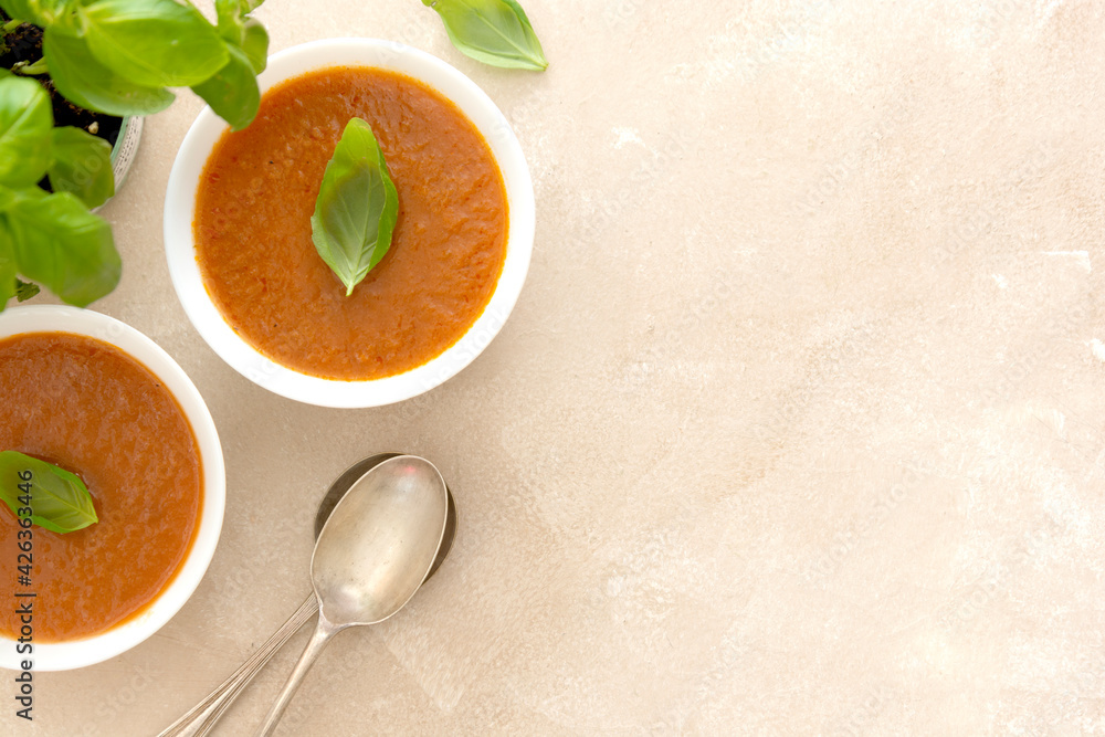Gazpacho cold tomato soup bowl with basil, bright background. Gazpacho cold tomato soup bowl with basil, bright background.
