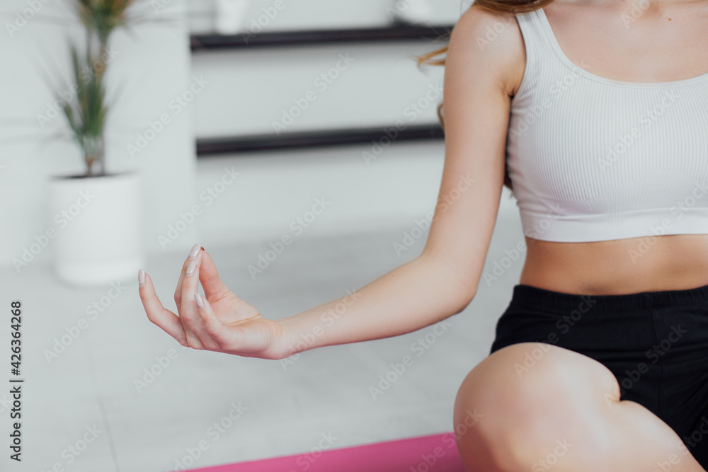 Close-up view of woman doing morning yoga after waking up at home, sitting in Easy pose, Sukhasana posture and meditating. Working out on the bed. Horizontal photo banner for website header design