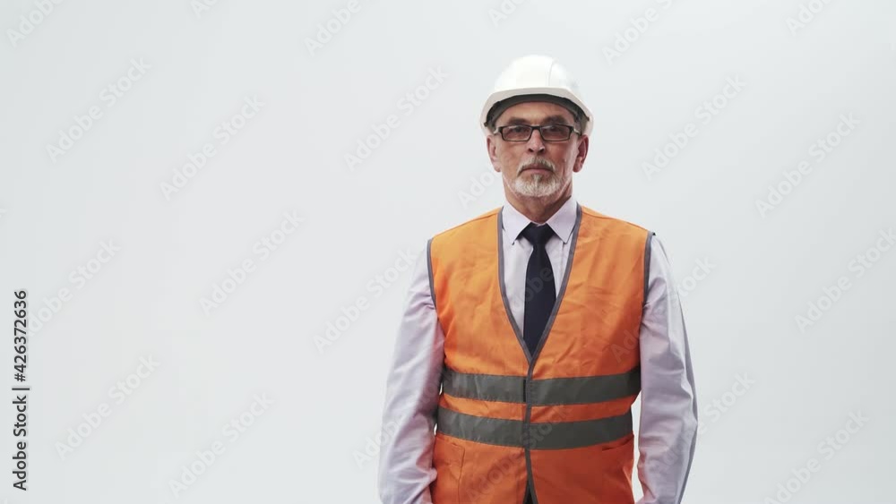 Studio Portrait Mature Man in Eyeglasses Middle Aged Engineer shows index finger to the side, standing in uniform on a studio white background. Caucasian adult engineer Studio Portrait Mature Man in Eyeglasses Middle Aged Engineer shows index finger to the side, standing in uniform on a studio white background. Caucasian adult engineer