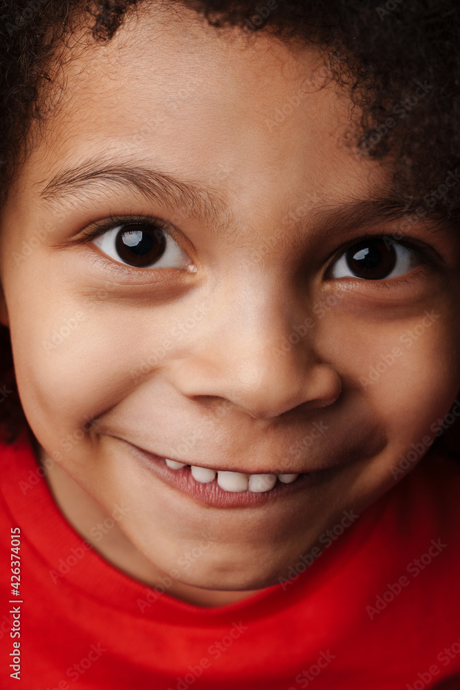 Smiling little child in everyday clothes over wall background Smiling little child in everyday clothes over wall background