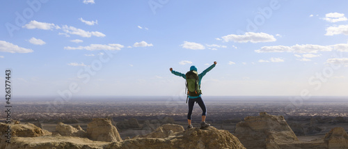 Successful female backpacker feel free on desert hill top