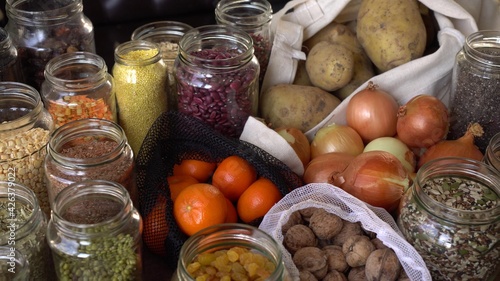 Home Grocery reserve. Zero waste pantry. Food shopping and storing in glass jars: grains, legumes, seeds, nuts, dried herbs, dried fruit, cereals, spices. Fruits and vegetables in reusable bags