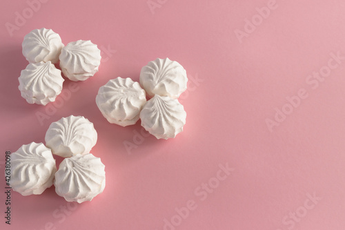 Round white airy sweet marshmallow on a pink background. Horizontal photo from above, background - food concept. 