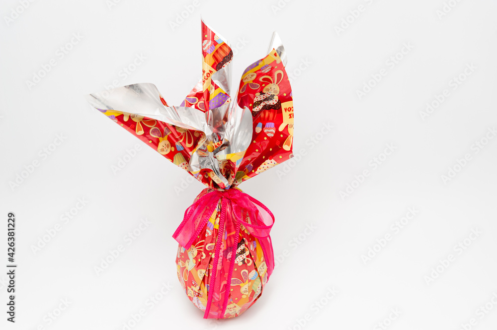 Easter Egg - Homemade chocolate egg with red ribbon. Isolated on white background. Copy space.