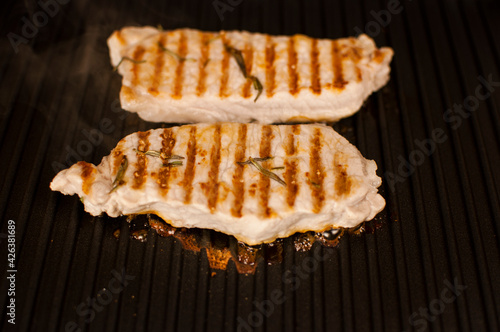 Barbecue party. Delicious pork steaks on a contact electric grill-close-up. Cooking in the home kitchen.