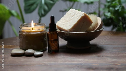 Spa background setting with natural soap, candle and oil bottle