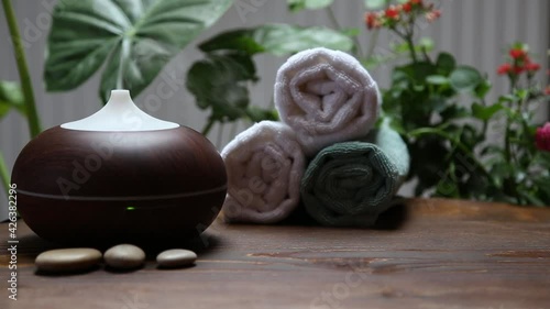 Spa background setting with aromatherapy diffuser and bath towels, wellness and spa