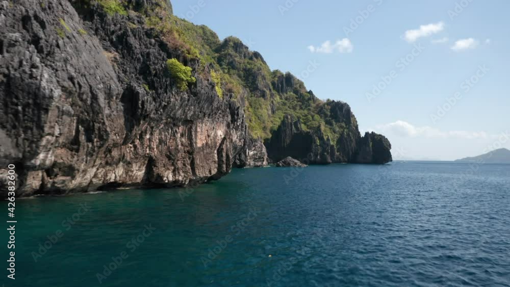 Drone shot over water showing cliffs en rocks on Matinloc Island, El Nido, Palawan, Philippines. Drone shot over water showing cliffs en rocks on Matinloc Island, El Nido, Palawan, Philippines.