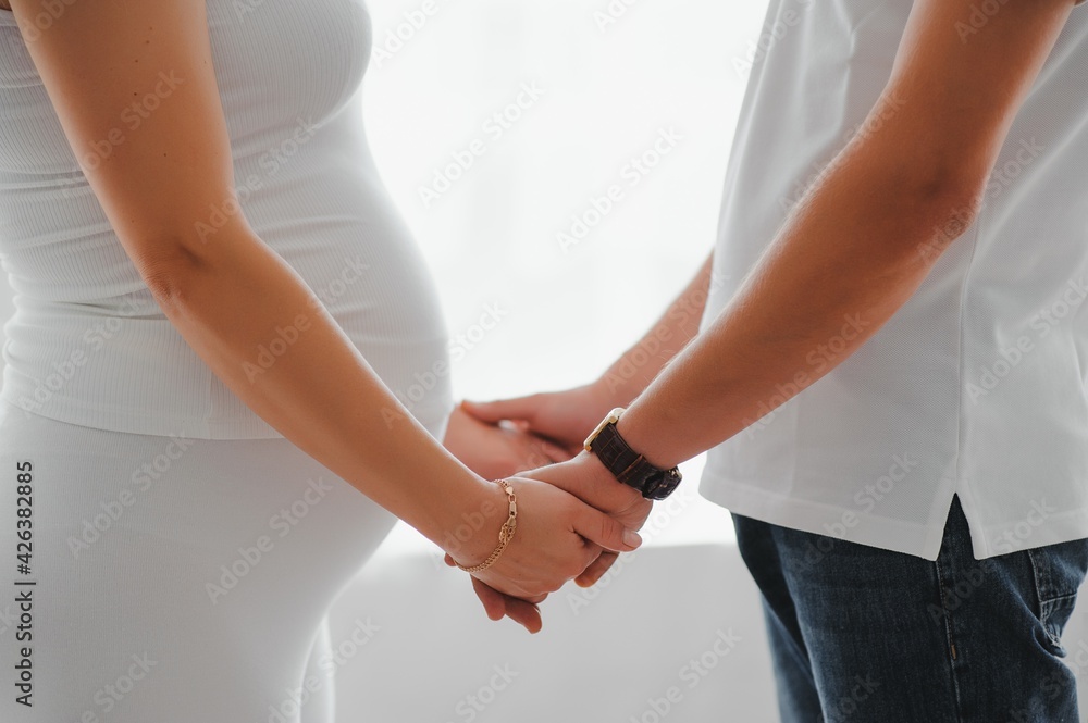 Fototapeta premium Image of pregnant couple. Husband touching his wife belly with hands