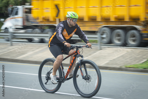 Konstfotografi Hombre obeso haciendo deprte montado  en una bicicleta por una carretera