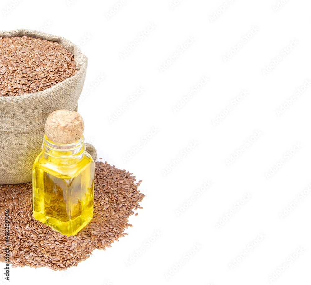 Flax essential oil. Glass bottle of Flax oil.Flax in a sack of isolated on a white background.. Healthy food. Vegan food. Superfood and vitamins Flax essential oil. Glass bottle of Flax oil.Flax in a sack of isolated on a white background.. Healthy food. Vegan food. Superfood and vitamins