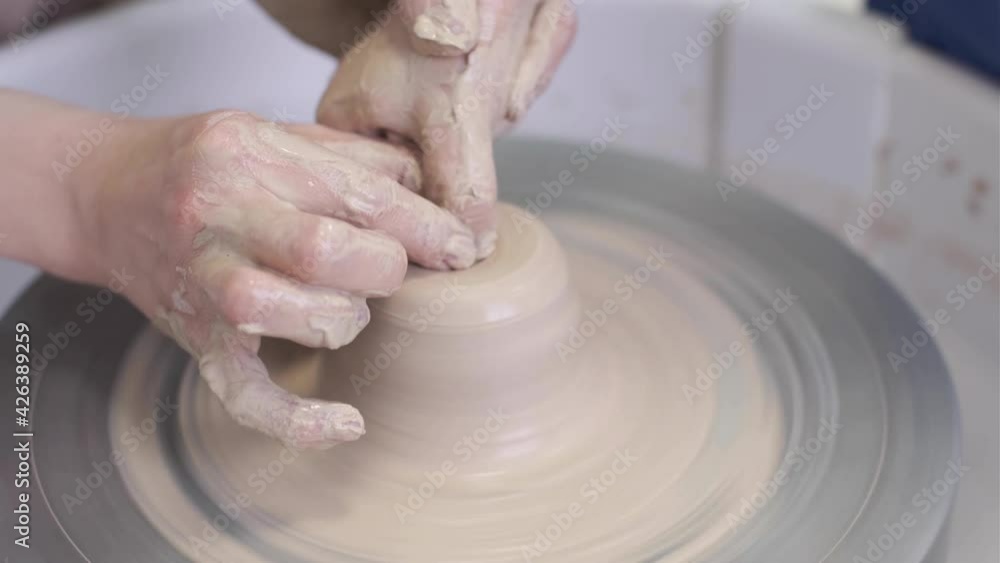 The master potter teaches the child to work with clay on a potter's wheel. The master potter teaches the child to work with clay on a potter's wheel.