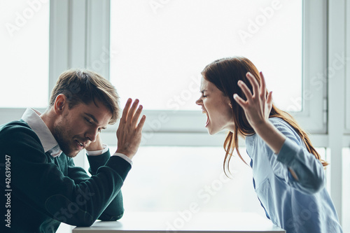 emotional man and woman sitting at the table conflict quarrel communication photo