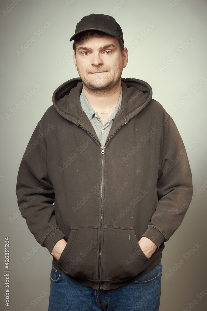 Man in black hooded shirt and black hat posing as criminal Man in black hooded shirt and black hat posing as criminal