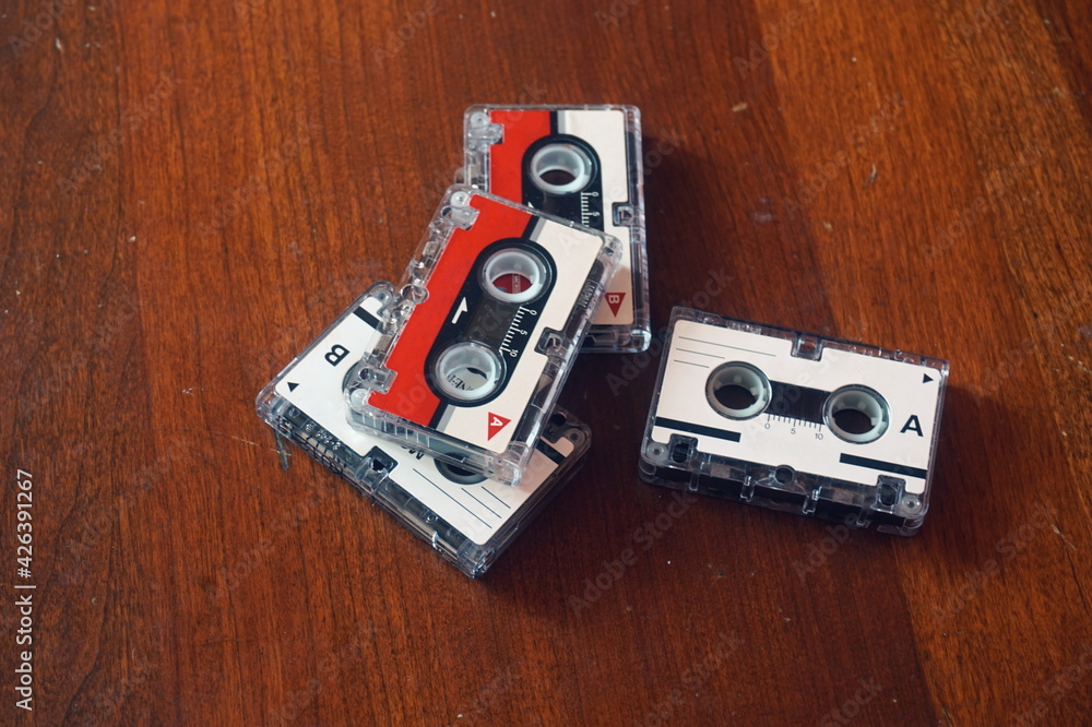 Four Mini Cassette Tapes Against Maple Wood Background Four Mini Cassette Tapes Against Maple Wood Background