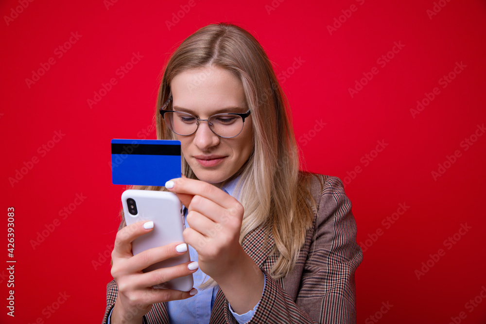 Young woman makes online purchases using a mobile phone Young woman makes online purchases using a mobile phone