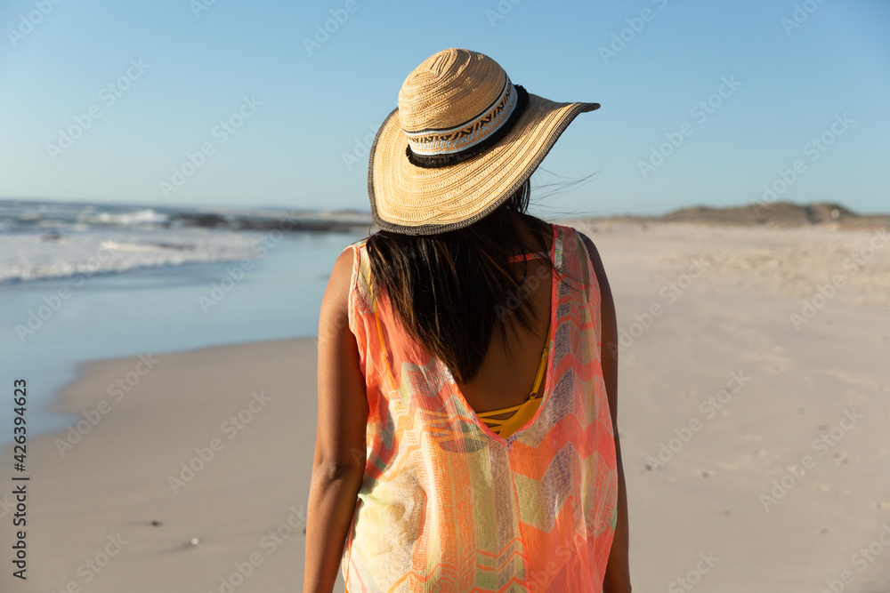 Happy mixed race woman on beach holiday looking away