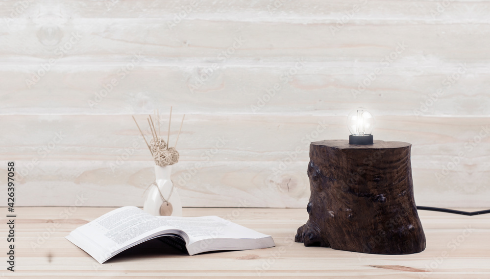 Desktop. Office. Decorative lamp made of wood on the table. Open book on the table. Bible