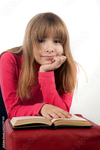 girl 10 years old keeps book smiles on white background portrait in studio