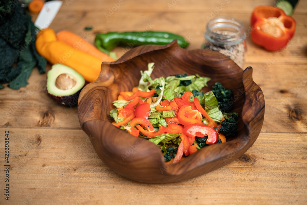Vegetable salad on wooden table with mix of black and white sesame seeds in a jar 