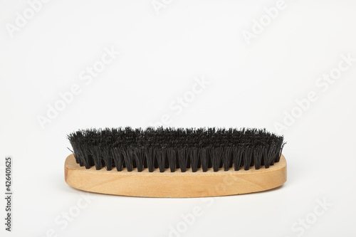 Brush for clothes and shoes made of wood. Clothes brush isolated on white background. Horsehair brush. Wooden clothes brush.