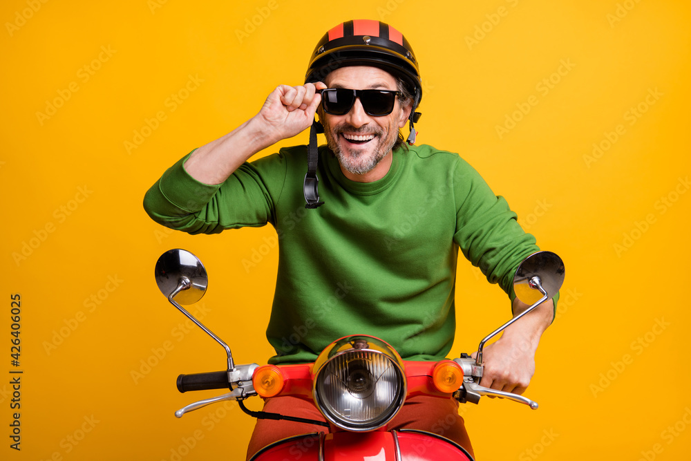 Photo of funky positive guy ride scooter wear helmet eyewear green sweater isolated yellow color background