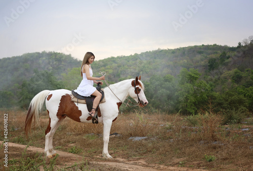 Women on skirt dress Riding Horses On field landscape Against Sky During Sunset