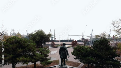 Aerial view of the square with a statue on a pedestal on the city embankment and the cargo seaport with. statue of Peter the great in Taganrog photo