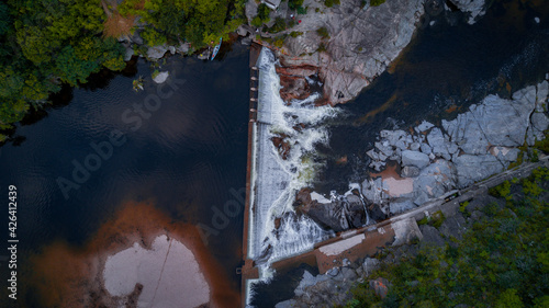 Photos represa de agua sobre rio crecido sobre pasando el limite del dique formando una