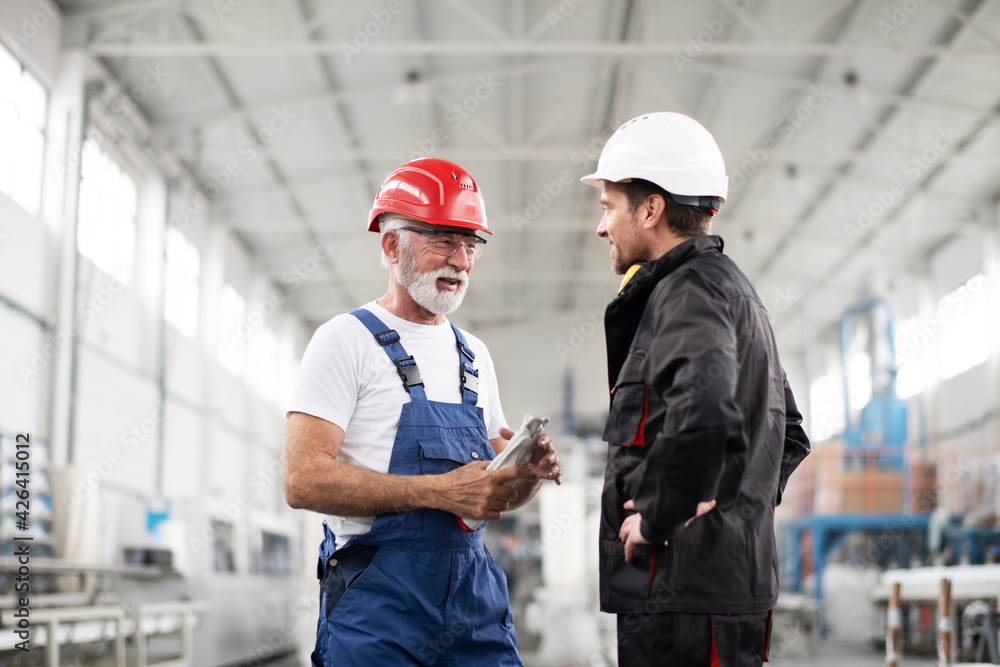 Portrait of workers in factory. Colleagues with helmet working in factory. Portrait of workers in factory. Colleagues with helmet working in factory.