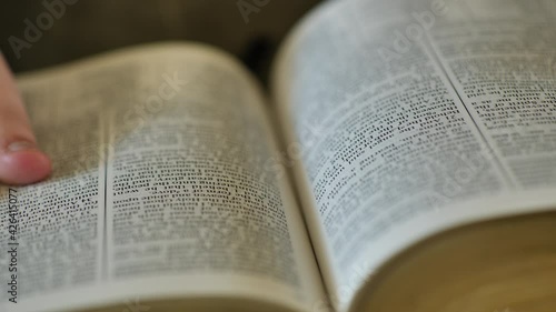 Turning the pages on scriptures.  A think amount of scriptures could represent an LDS Triple combination. photo