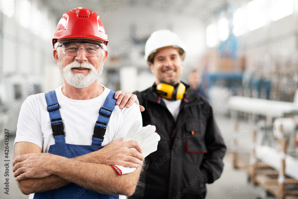 Portrait of workers in factory. Colleagues with helmet working in factory. Portrait of workers in factory. Colleagues with helmet working in factory.