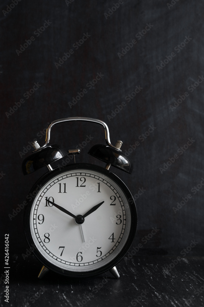 Retro alarm clock on wooden table Against Black Background Retro alarm clock on wooden table Against Black Background