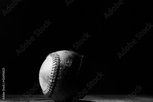 Photography Dark baseball ball close up with black background.
