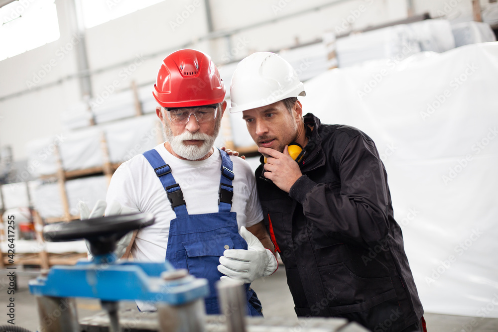 Portrait of workers in factory. Colleagues with helmet working in factory.. Portrait of workers in factory. Colleagues with helmet working in factory..