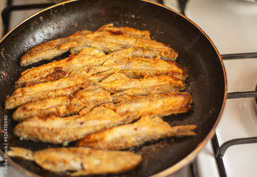 capelin in a pan fried in corn flour, Mallotus villosus - sea ray-finned fish of the smelt family, simple homemade food fried fish, simple homemade food concept, home cooking capelin in a pan fried in corn flour, Mallotus villosus - sea ray-finned fish of the smelt family, simple homemade food fried fish, simple homemade food concept, home cooking