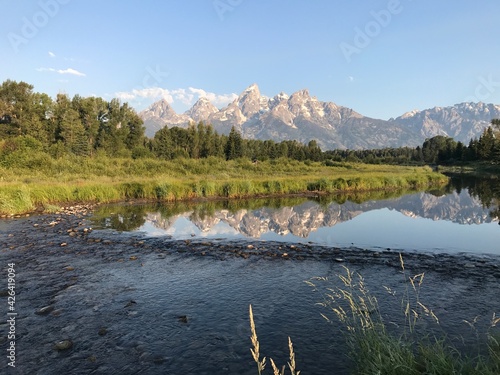 The peaks of the Grand Tetons rise above a quiet bubbling stream