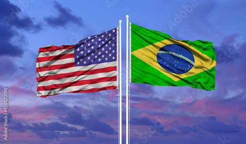 Two waving state flags of United States and Brazil on the blue sky. High - quality business background. 3d illustration