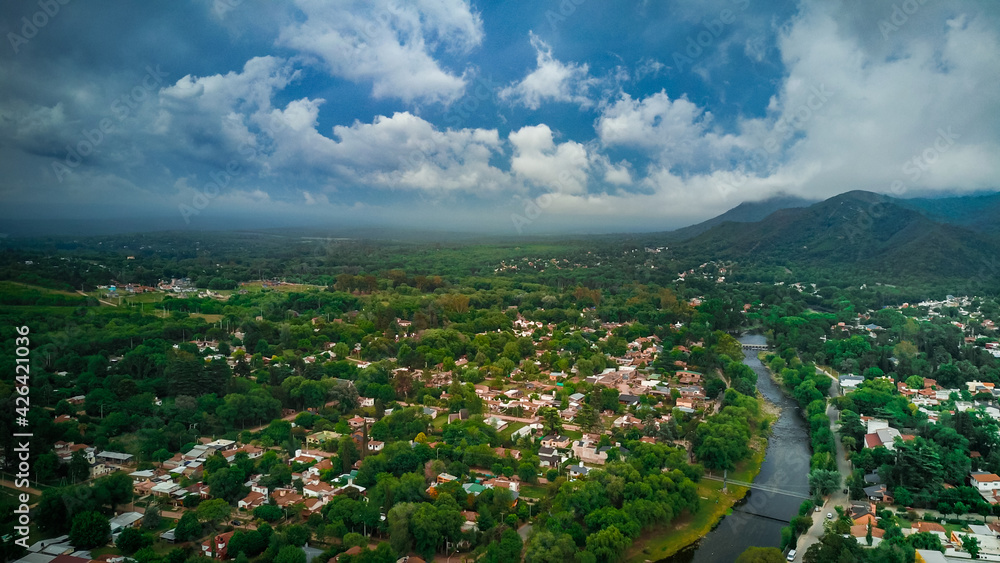 Ciudad de Santa Rosa de Calamuchita, ubicada en la zona serrana de la Provincia de Córdoba Argentina. Foto Aérea tomada con drone de la ciudad al costado de las montañas en un día tormentoso.