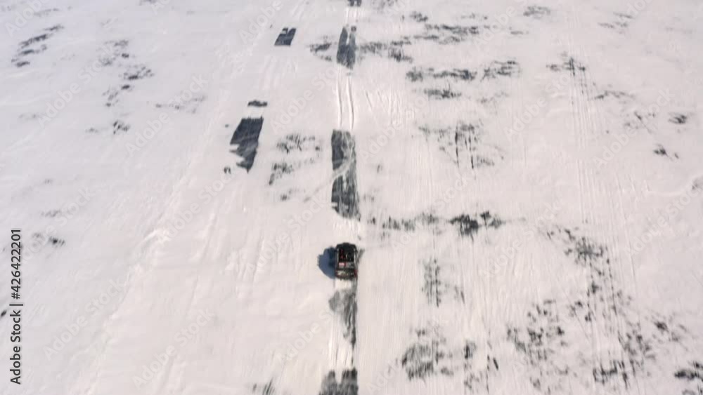 The car is driving on the ice with a view of the endless expanses of
