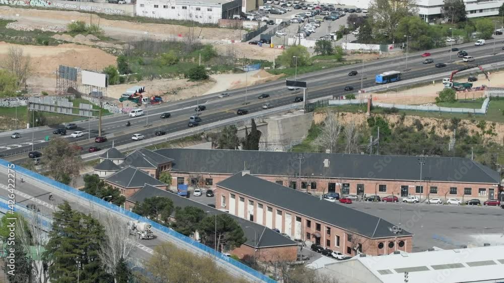 aerial view of highway street in madrid with flowing traffic. There are industries and houses around aerial view of highway street in madrid with flowing traffic. There are industries and houses around