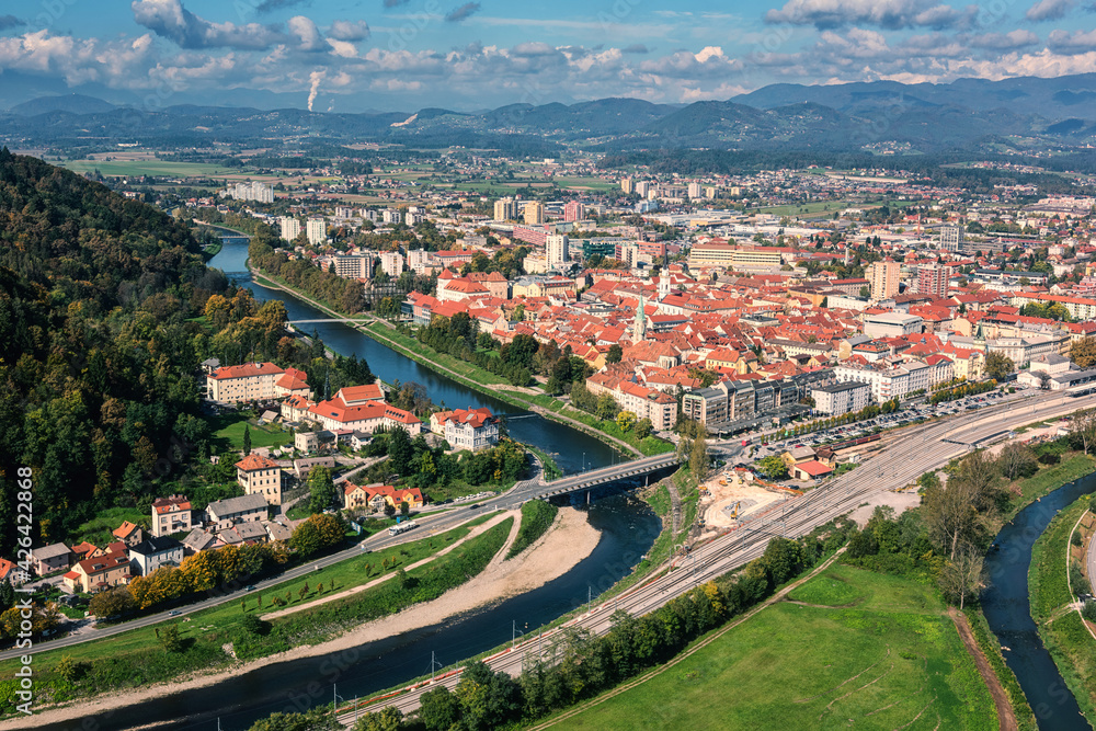 Scenic aerial view of the Celje city in Slovenia, Styria from old castle ancient walls. Amazing landscape with town in Lasko valley, river Savinja and blue sky with clouds, outdoor travel background